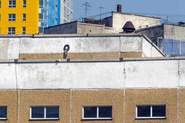 istock Development in Tight Urban Spaces. Chaotic Rooftops of Various Buildings with Web of Cable Wire Lines, TV Antennas, Concrete Slabs, Brickwork. 1148589043