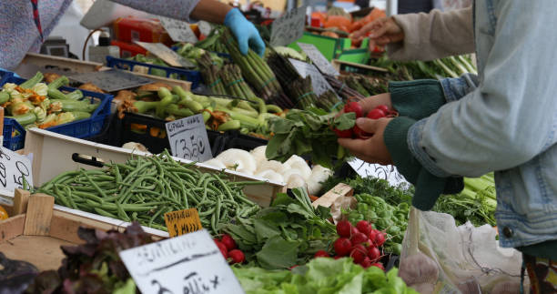 istock Women buying vegetables at market stall 1148590121