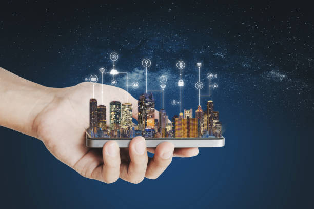 istock Smart city, building technology and mobile application technology. Hand holding mobile smart phone with buildings hologram and application programming interface technology 1148590433