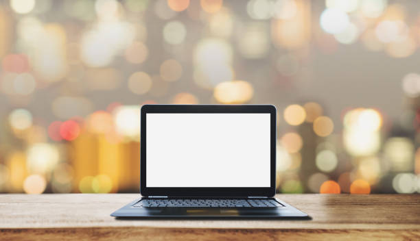 istock Computer laptop blank white screen on wooden desk, with blurry Bokeh light background 1148590518