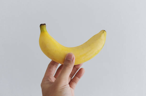 Hand holding banana, on white background