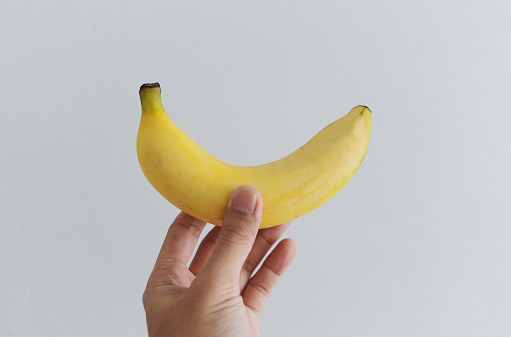 Hand holding banana, on white background