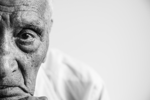 An old man with wrinkles close up. Black and white photo.