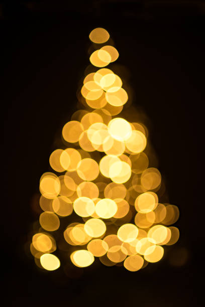 istock Golden Christmas tree with decorations and lights bokeh in a black background 1148592900