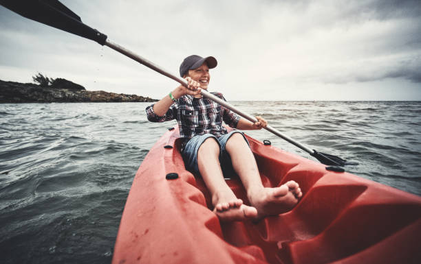 istock Teenage boy kayaking at sunset 1148593852