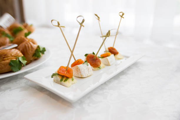 Buffet dishes.Canapes on a white plate. Small sandwiches on a stick. Snack