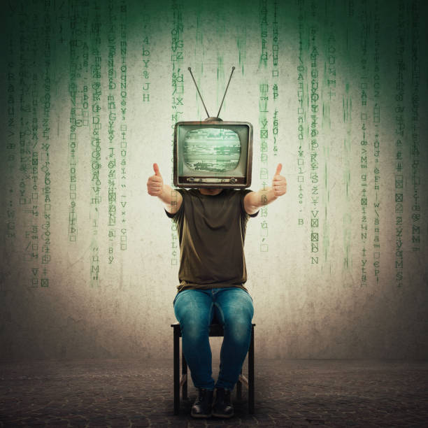 возбужденный человек сидит на стуле со старым телевизором вместо головы, показывая большие пальцы вверх, положительные отзывы, как жест - brain wash стоковые фото и изображения