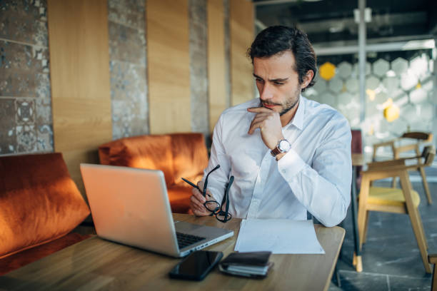 istock Businessman working on laptop in cafe 1148599898
