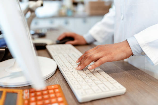 Medicine doctor working with PC computer at desk in the hospital Closeup of pharmacist's hands typing on a computer keyboard at the pharmacy counter. Photo of a female pharmacist using a computer at the hospital pharmacy. Pharmacist searching for a product in the computer database, healthcare, and technology concept. pharmacy tech stock pictures, royalty-free photos & images