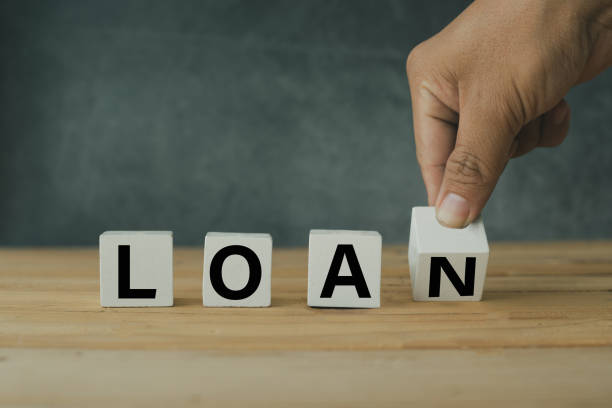 istock finance and banking concept, Hand putting wooden loan shape on table 1148601678