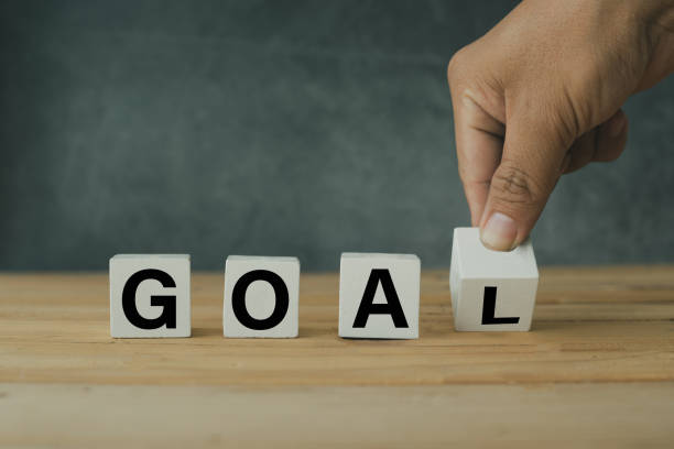 istock Success and target concept, Hand putting wooden goal shape on table 1148601689