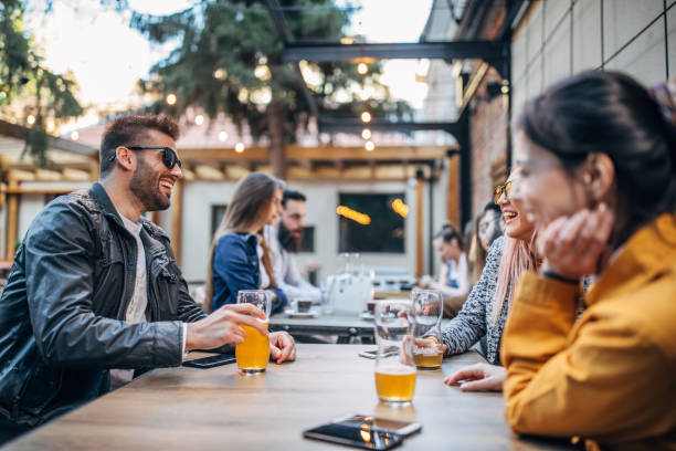 istock Group of young joyful friends having fun in a pub 1148602180