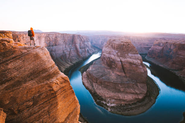 мужской турист с видом на подкову бенд на закате, аризона, сша - glen canyon стоковые фото и изображения