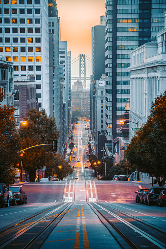 Classic view of downtown San Francisco with famous Oakland Bay Bridge illuminated in first golden morning light at sunrise in summer, San Francisco, California, USA