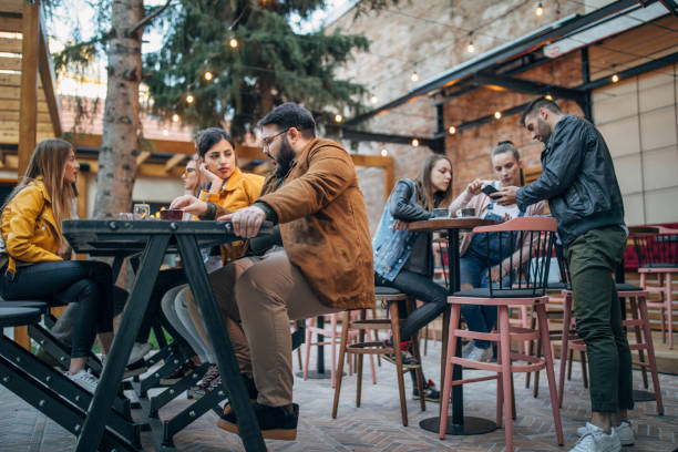 istock Group of young joyful friends having fun in a pub 1148602361