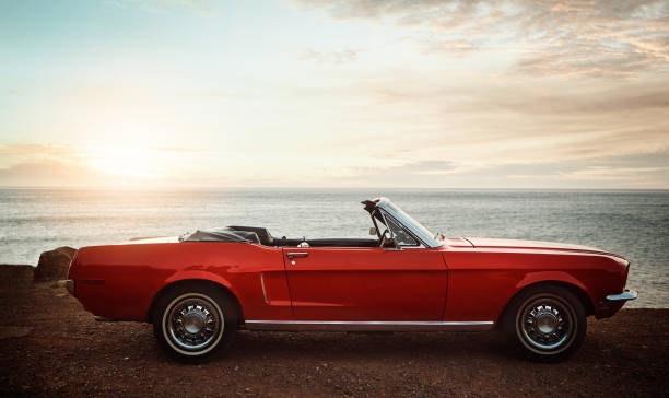 Many memories were made in this car Shot of an empty vintage car parked along the coast at sunset convertible stock pictures, royalty-free photos & images