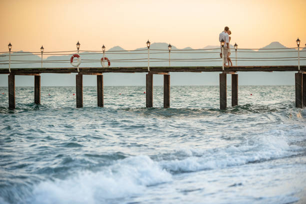 istock Couple hugging together on jetty 1148605565