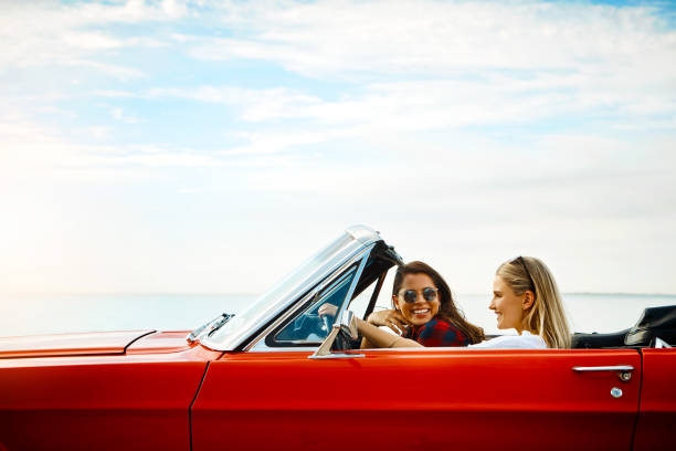 Woman driving car with arm in the air feeling the breeze at san juan island,usa.