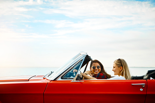 Shot of a two happy young women enjoying a summer’s road trip together