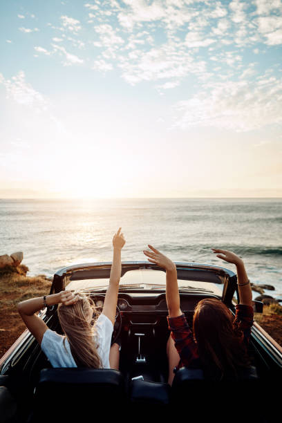 Where will this summer take you? Shot of a two happy young women enjoying a summer’s road trip together convertible stock pictures, royalty-free photos & images
