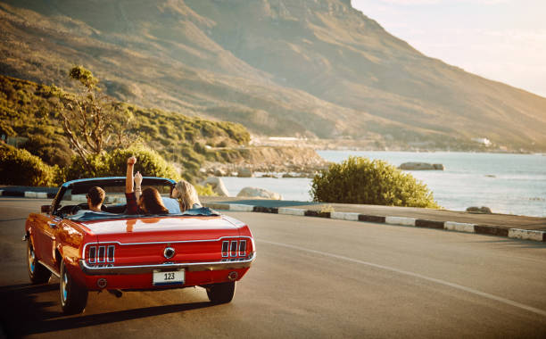 Embrace the open road with open arms Shot of happy young friends enjoying a summer’s road trip together convertible stock pictures, royalty-free photos & images