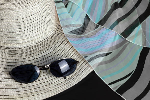 White straw hat, a black, blue and purple foulard and a pair of sunglasses