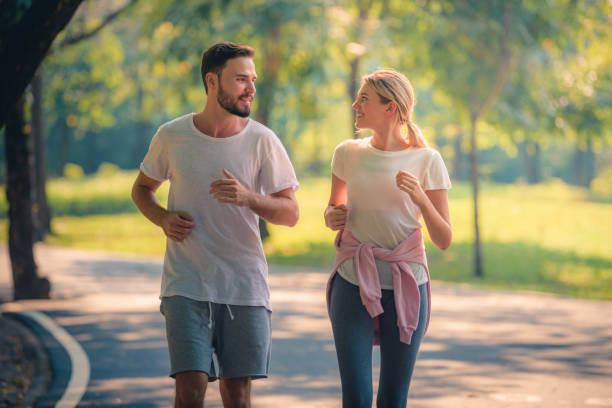 chân dung cặp vợ chồng trẻ chạy trong công viên lúc hoàng hôn. khái niệm thể thao và tình yêu. giọng điệu ấm áp. - đi bộ thể dục hình ảnh sẵn có, bức ảnh & hình ảnh trả phí bản quyền một lần
