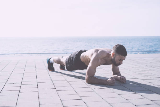 istock Athletic build man doing plank outdoors 1148610847