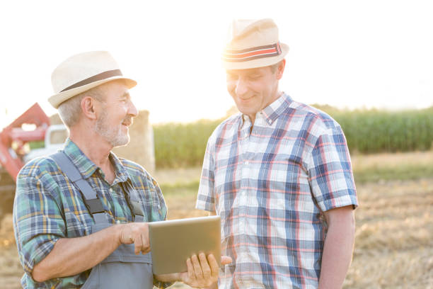 istock Smiling farmers communicating over digital tablet at farm 1148611058