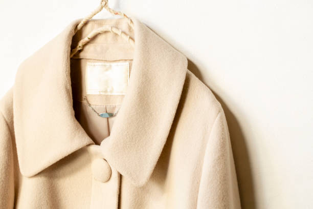 istock beige wool coat hanging on clothes hanger on white background 1148611066