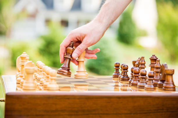istock Man playing chess on board outdoors 1148611176