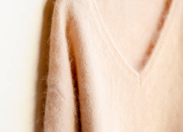 istock light pink sweater hanging on clothes hanger on white background. 1148611241
