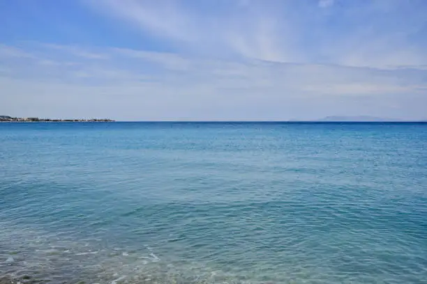 calm sea of turquoise color and some clouds in the blue sky