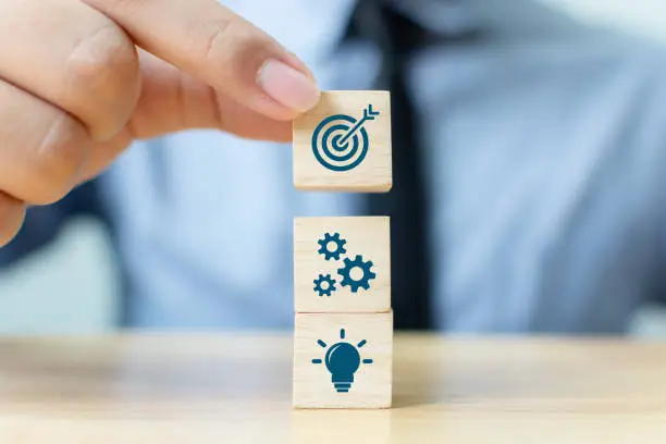 Photo of Concept of business strategy and action plan. Businessman hand putting wood cube block on top with icon