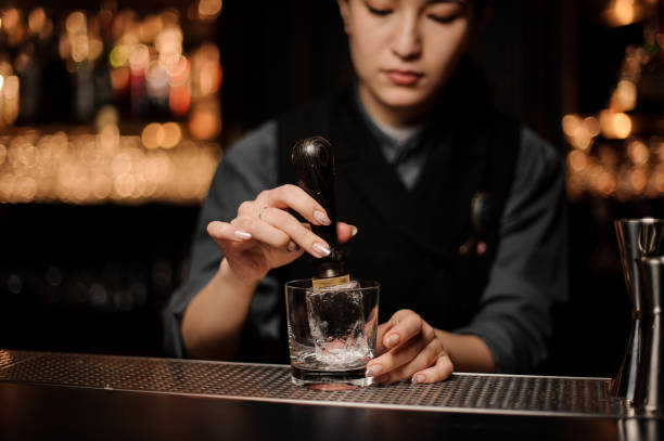 istock Bartender adds ice in glass with an ice picker 1148615502