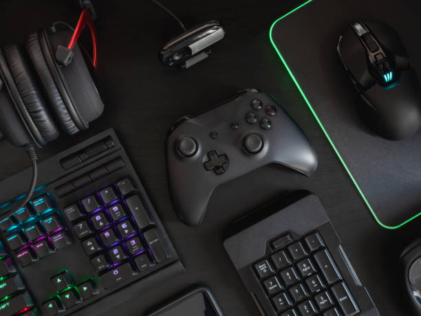 istock gamer workspace concept, top view a gaming gear, mouse, keyboard, joystick, headset, mobile joystick and mouse pad on black table background with RGB color. 1148617286
