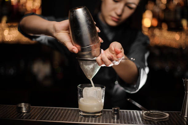 istock Close shot of bartender preparing cocktail adding sour mix in glass 1148617435
