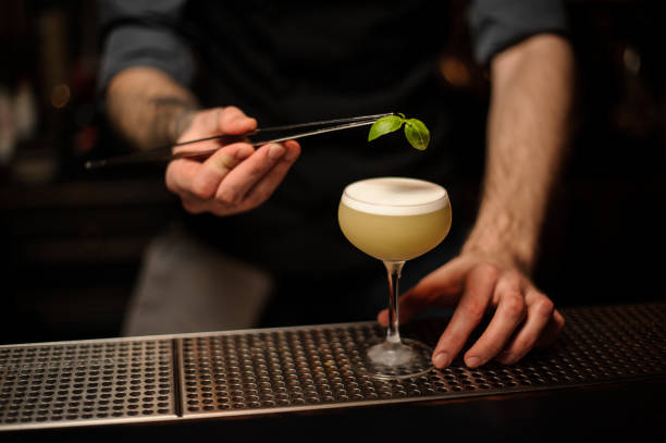 istock Close-up of bartender pouring cocktail using forceps 1148618859