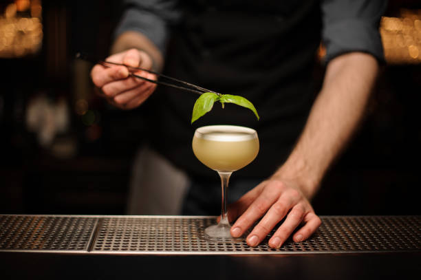 istock Close-up of the bartender pouring cocktail using forceps 1148619201