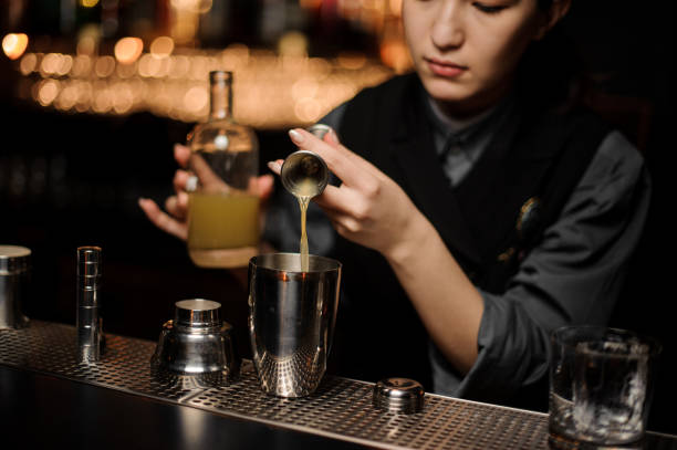 istock Female bartender pouring cocktail adding sour mix in the shaker 1148619341