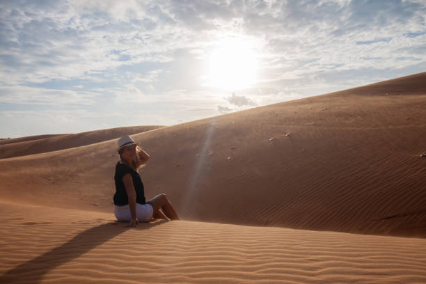 istock Woman standing barefoot on the dune in the desert 1148620507