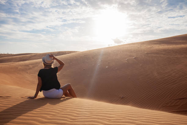 istock Woman standing barefoot on the dune in the desert 1148620932
