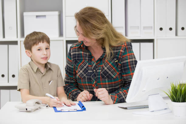 istock Teacher with a primary school student.Mom in the office with a child 1148623937