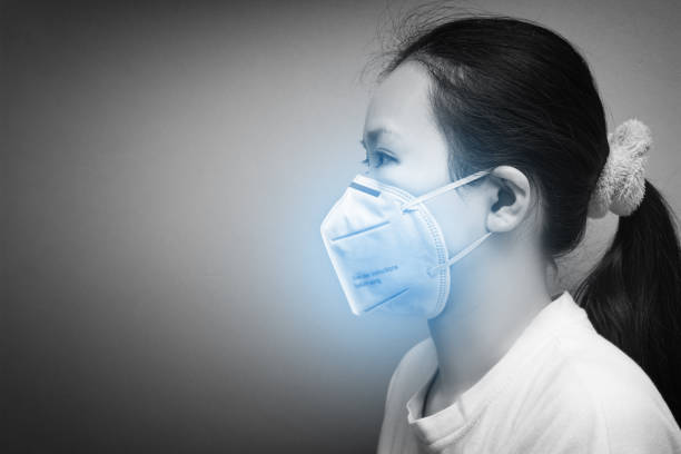 vista lateral de retrato de mujer asiática usando máscara respiratoria n95 para proteger la contaminación del aire - pig flu fotografías e imágenes de stock