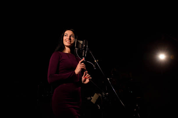 istock Singer recording a song in music studio. 1148624225