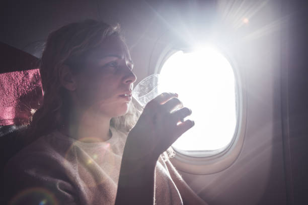 istock Young female drinking water in the plane. 1148625101