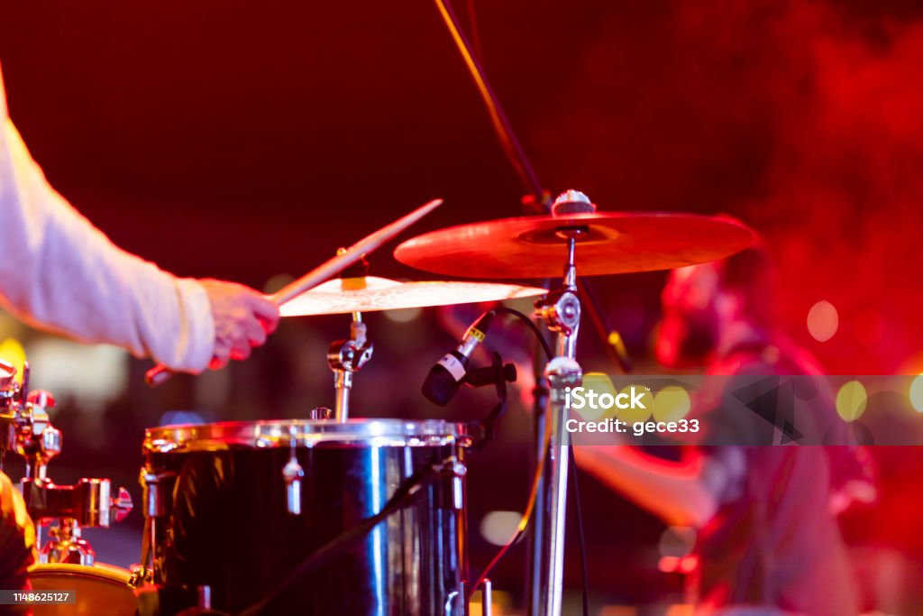 Drummer playing drums on stage Performance Group Stock Photo