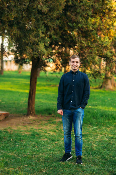 istock Man in dark blue shirt standing in the park 1148625390