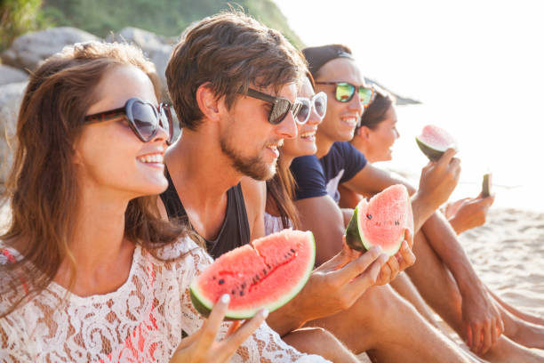 istock Friends eating watermelon on beach 1148625530