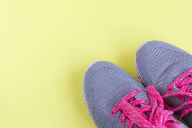 istock grey sneakers with pink laces on light yellow background 1148626362